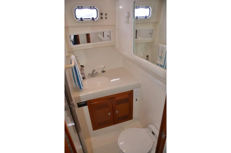Slide: The Image of Bathroom interior of 2001 Cabo 35 Flybridge yacht with sink, mirror, and toilet. - 36