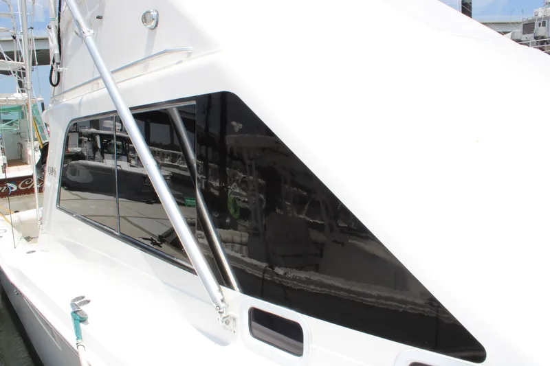 Slide: The Image of 2001 Cabo 35 Flybridge boat with sleek black windows docked at marina. - 4