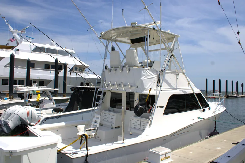 Slide: The Image of 2001 Cabo 35 Flybridge boat docked at marina under clear blue sky. - 5