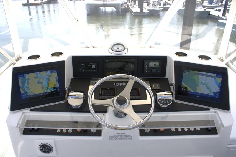Slide: The Image of Helm of 2001 Cabo 35 Flybridge with navigation screens and steering wheel. - 7