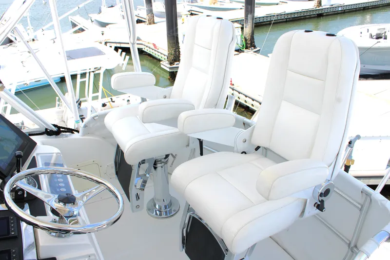 Slide: The Image of Flybridge of 2001 Cabo 35 with white captain chairs and steering wheel. - 9