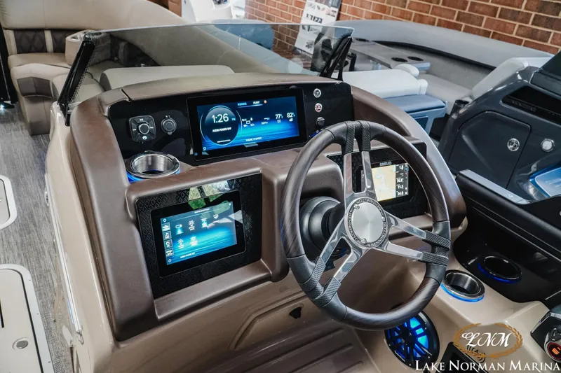 Slide: The Image of 2026 Bennington 24LXSSB boat dashboard with modern controls and steering wheel at Lake Norman Marina. - 14