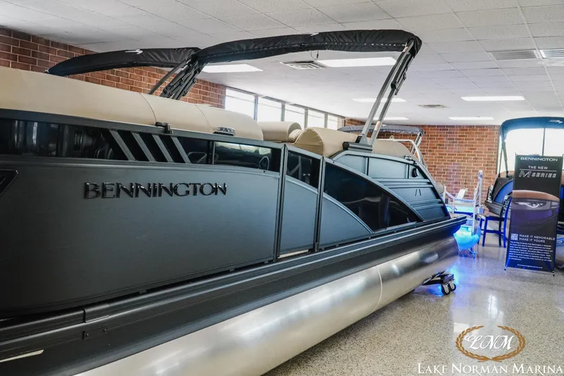 Slide: The Image of 2026 Bennington 24LXSSB pontoon boat displayed indoors at Lake Norman Marina. - 3