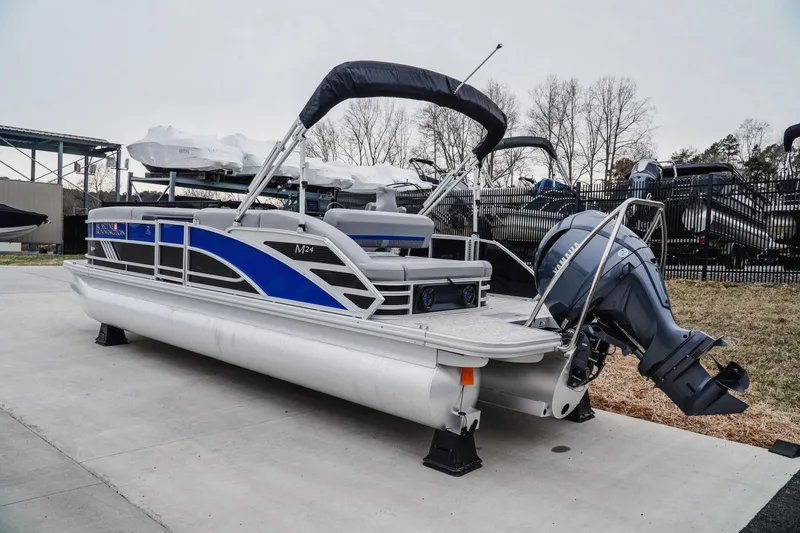 Slide: The Image of 2025 Bennington 24MSB pontoon boat with blue accents and outboard motor. - 3