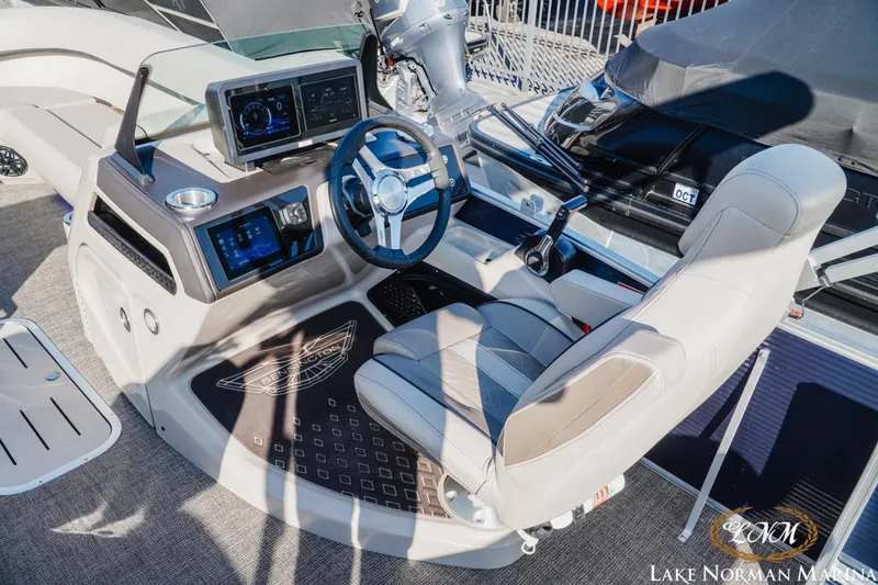 Slide: The Image of 2025 Bennington 24MSB boat helm with modern controls and comfortable seating at Lake Norman Marina. - 8