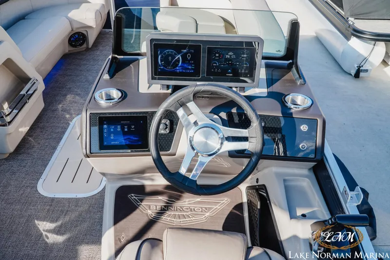 Slide: The Image of 2025 Bennington 24MSB boat dashboard with modern controls and steering wheel. - 9