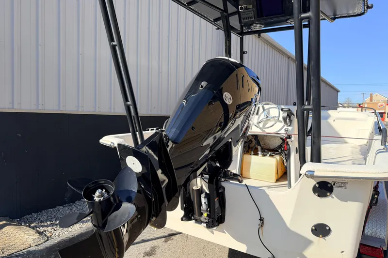 Slide: The Image of 2017 Carolina Skiff 258 DLV boat with outboard motor, docked near a building. - 5