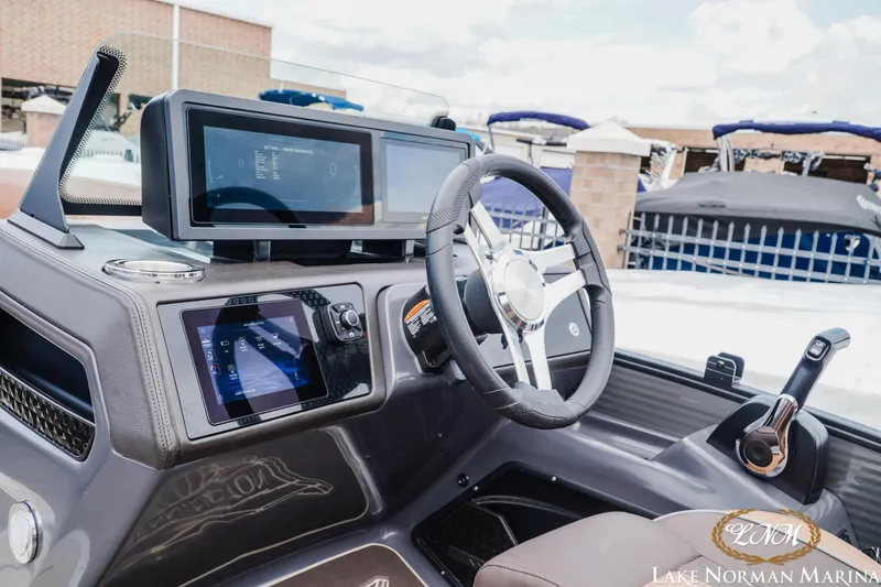 Slide: The Image of 2025 Bennington 24MSB boat dashboard with modern controls and steering wheel at Lake Norman Marina. - 19