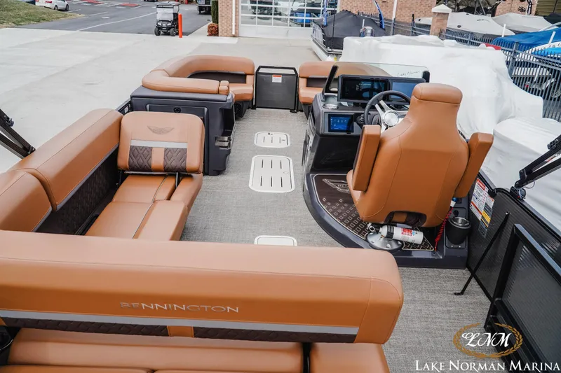 Slide: The Image of 2025 Bennington 24MSB pontoon boat interior with luxurious tan seating and modern dashboard. - 6