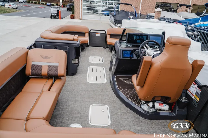 Slide: The Image of 2025 Bennington 24MSB pontoon boat interior with luxurious tan seating and modern dashboard. - 8