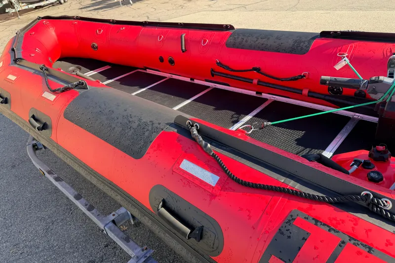 Slide: The Image of Red 2025 Inmar 530RHD inflatable boat on trailer, showcasing interior and exterior details. - 8