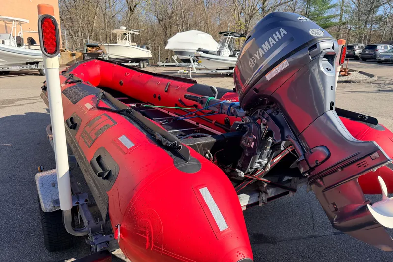 Slide: The Image of Red 2025 Inmar 530RHD inflatable boat with Yamaha outboard motor on a trailer. - 9