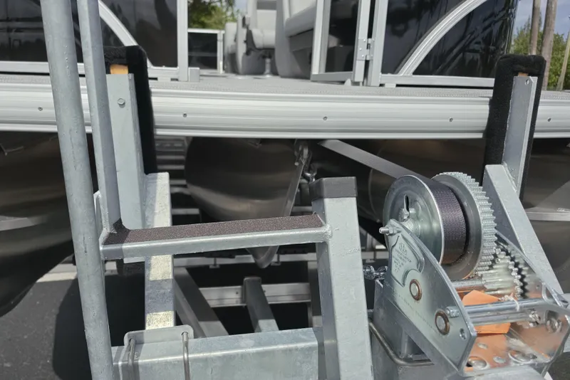 Slide: The Image of 2026 Sun Tracker Party Barge 24 XP3 on trailer, close-up of winch and pontoon. - 84