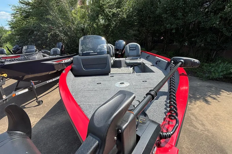 Slide: The Image of 2026 Tracker Pro Guide V-16 SC boat with red trim, parked outdoors. - 3