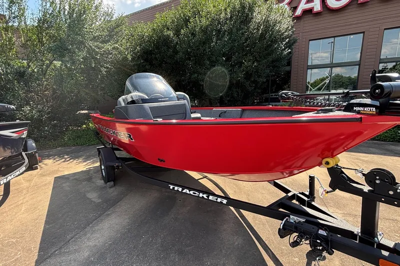Slide: The Image of Red 2026 Tracker Pro Guide V-16 SC boat on trailer, parked outdoors. - 2
