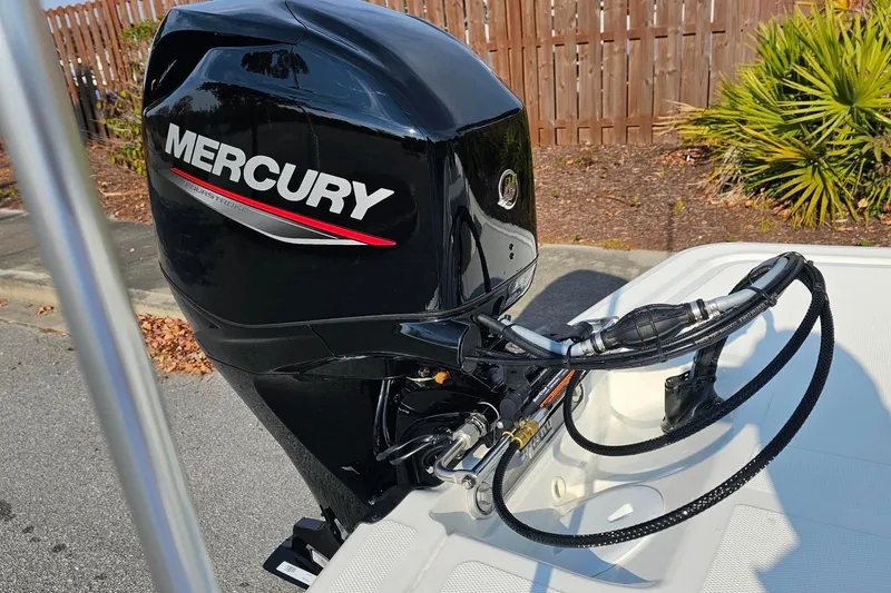 Slide: The Image of Mercury outboard motor on 2026 Mako Pro Skiff 15 CC boat, parked outdoors. - 7