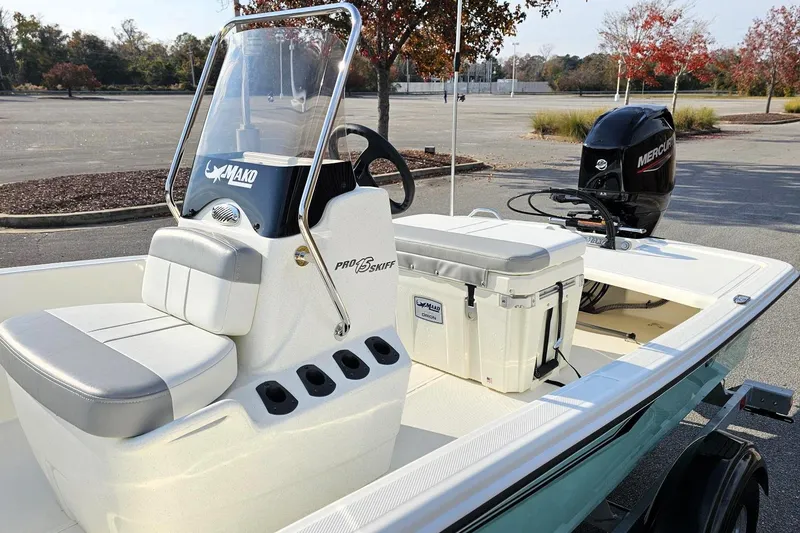 Slide: The Image of 2026 Mako Pro Skiff 15 CC boat with Mercury engine in a parking lot. - 11