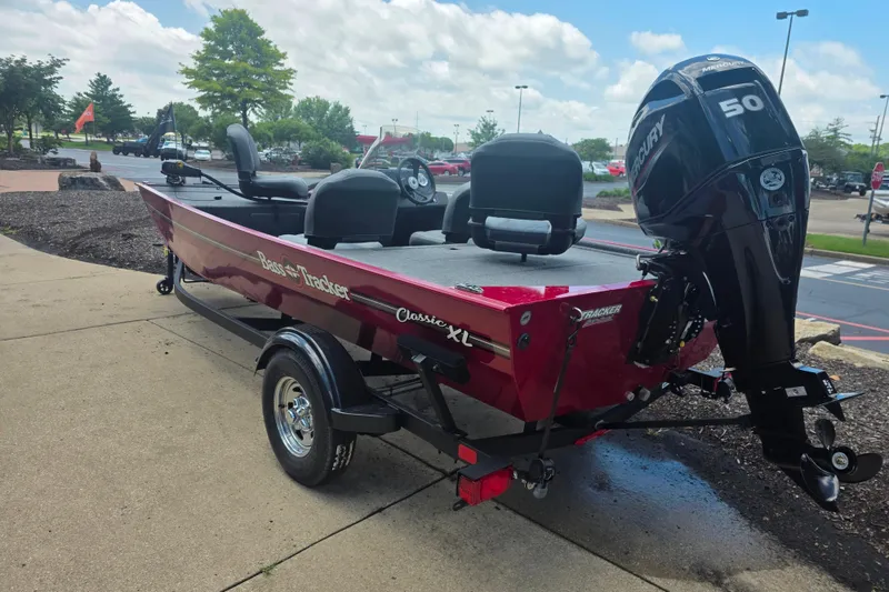Slide: The Image of 2026 Tracker Bass Tracker Classic XL boat with Mercury 50 engine, parked outdoors. - 2
