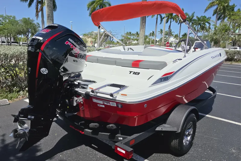 Slide: The Image of 2026 Tahoe T18 boat with Mercury engine, parked on trailer, sunny day, palm trees in background. - 10