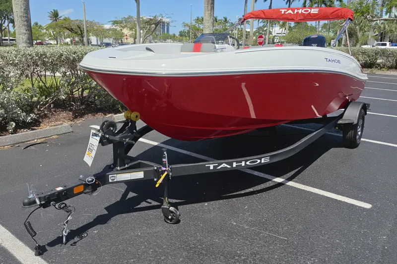 Slide: The Image of 2026 Tahoe T18 boat with red hull on trailer in sunny parking lot. - 2