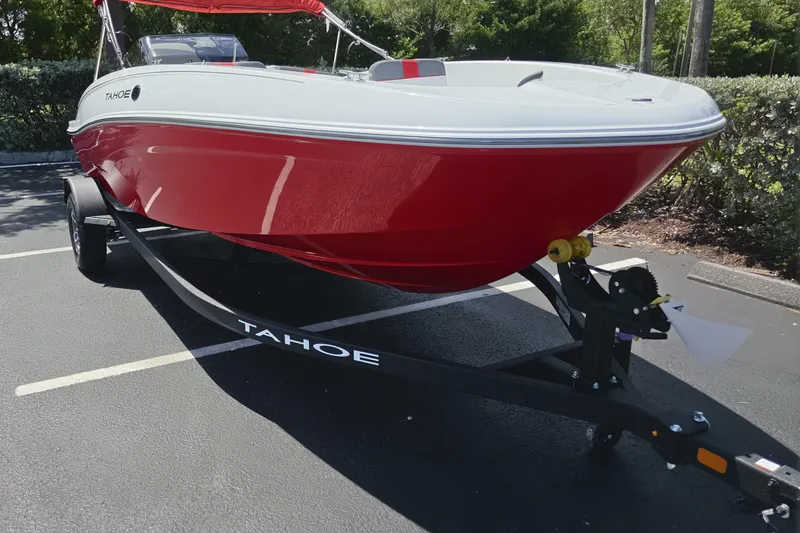 Slide: The Image of 2026 Tahoe T18 boat in vibrant red on a trailer, parked outdoors. - 3