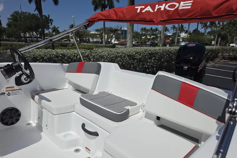 Slide: The Image of 2026 Tahoe T18 boat interior with red and gray seating, steering wheel, and canopy. - 7