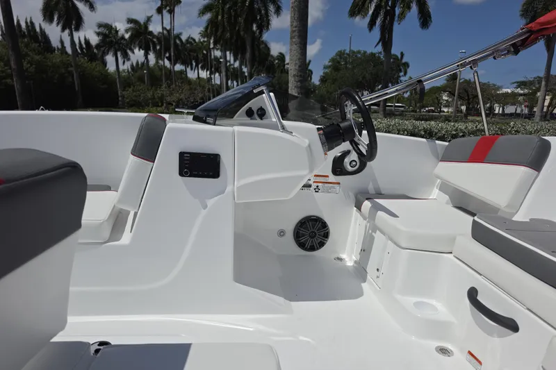 Slide: The Image of 2026 Tahoe T18 boat interior with steering wheel, seating, and palm trees in the background. - 9
