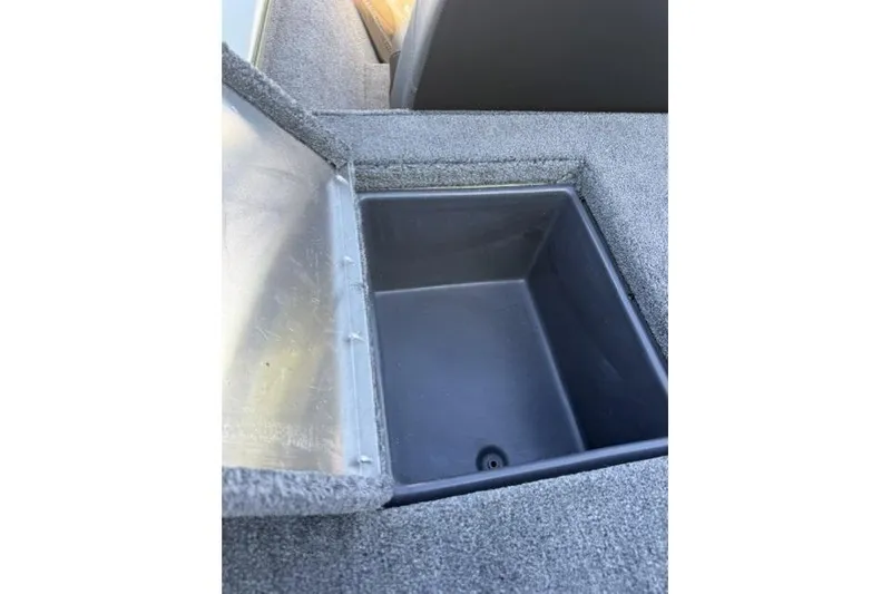 Slide: The Image of Open storage compartment in 2026 Tracker Pro Team 195 boat, featuring carpeted interior. - 10