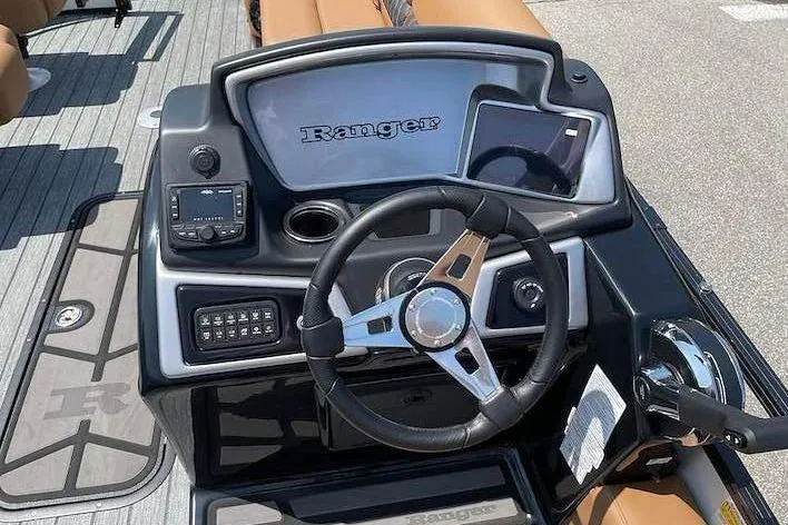Slide: The Image of The image shows the helm of a Ranger 223FC boat with a modern steering wheel and instruments. - 14