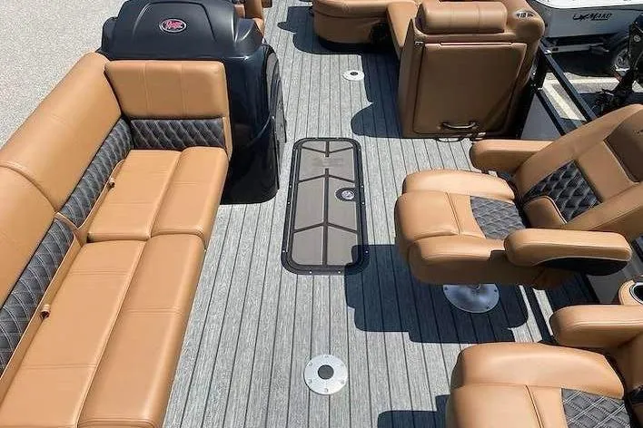 Slide: The Image of Interior of a 2026 Ranger 223FC with brown leather seating and gray flooring. - 11