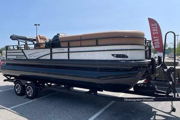 The Image of 2026 Ranger 223FC pontoon boat on a trailer, featuring brown seating and a sale sign. - 0