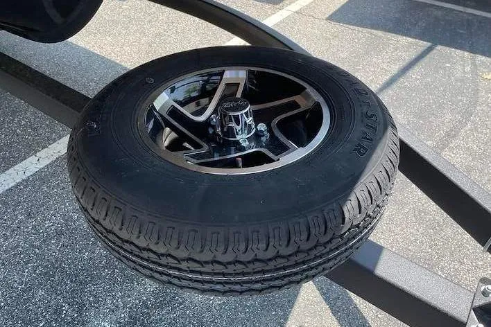 Slide: The Image of A spare tire with a black rim is mounted on a trailer. - 16