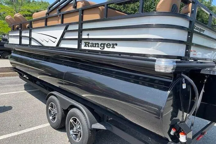 Slide: The Image of A 2026 Ranger 223FC pontoon boat on a trailer. It features black and white detailing. - 2