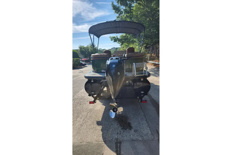 Slide: The Image of 2026 Regency 230 DL pontoon boat with canopy, parked outdoors on a sunny day. - 3