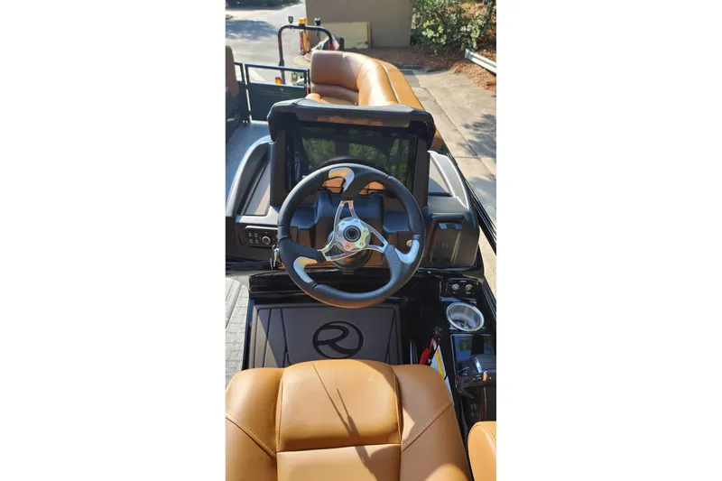Slide: The Image of 2026 Regency 230 DL boat interior with steering wheel and tan seating. - 6