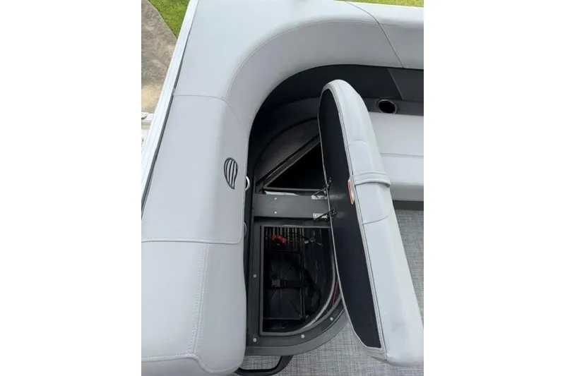 Slide: The Image of 2026 Sun Tracker Party Barge 16 DLX storage compartment with open seat cushion. - 10