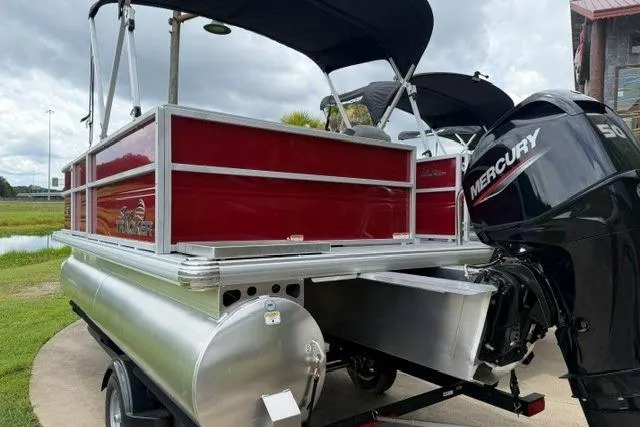 Slide: The Image of 2026 Sun Tracker Party Barge 16 DLX pontoon boat with Mercury engine, docked outdoors. - 3