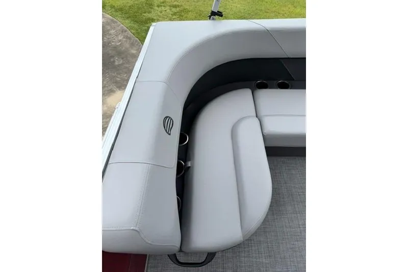 Slide: The Image of 2026 Sun Tracker Party Barge 16 DLX seating area with cup holders and gray upholstery. - 9