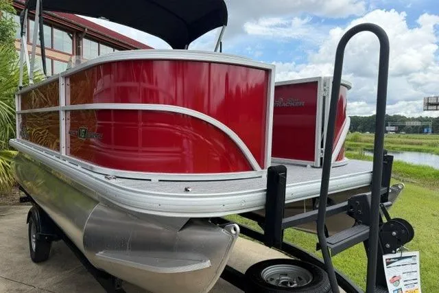 The Image of 2026 Sun Tracker Party Barge 16 DLX pontoon boat on trailer, red exterior. - 0
