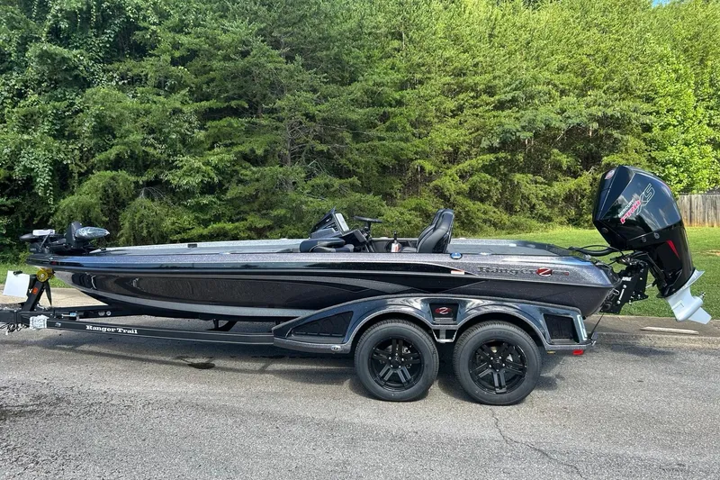 The Image of 2026 Ranger Z520R Cup-Equipped boat on trailer, parked on a road with lush greenery. - 0