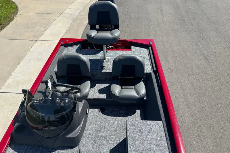 Slide: The Image of 2026 Tracker Pro 170 boat with gray seating and red trim, parked on pavement. - 13