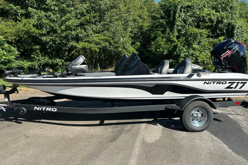 The Image of 2026 Nitro Z17 boat on trailer, parked outdoors with lush greenery background. - 0