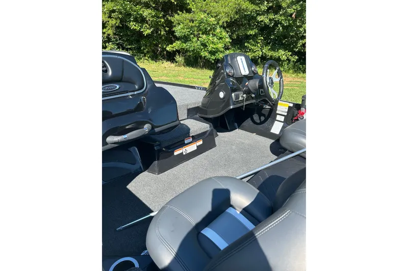 Slide: The Image of 2026 Nitro Z17 boat interior with steering wheel and seating, surrounded by lush greenery. - 5