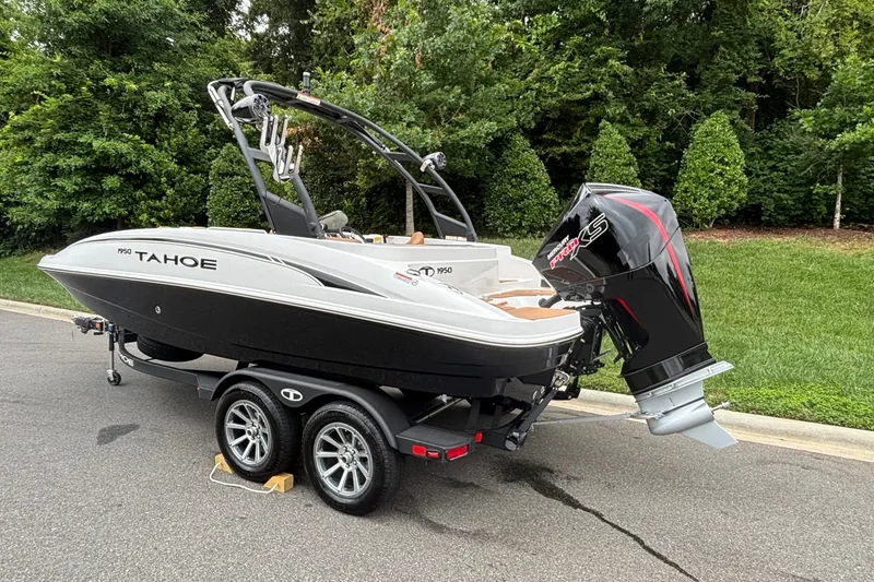 Slide: The Image of 2026 Tahoe 1950 boat on trailer, parked on road with lush greenery background. - 5