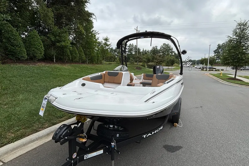 Slide: The Image of 2026 Tahoe 1950 boat on trailer, parked on a suburban street with lush greenery. - 3