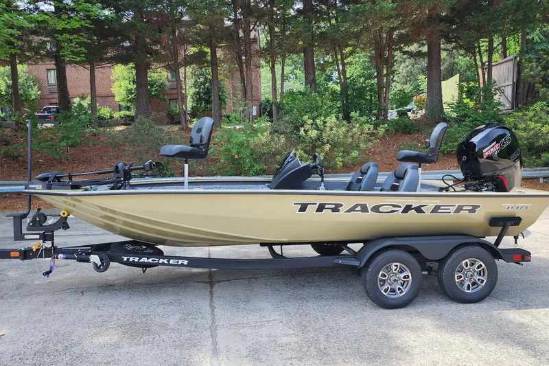 The Image of 2026 Tracker Pro Team 195 boat on trailer, parked outdoors with trees in background. - 0