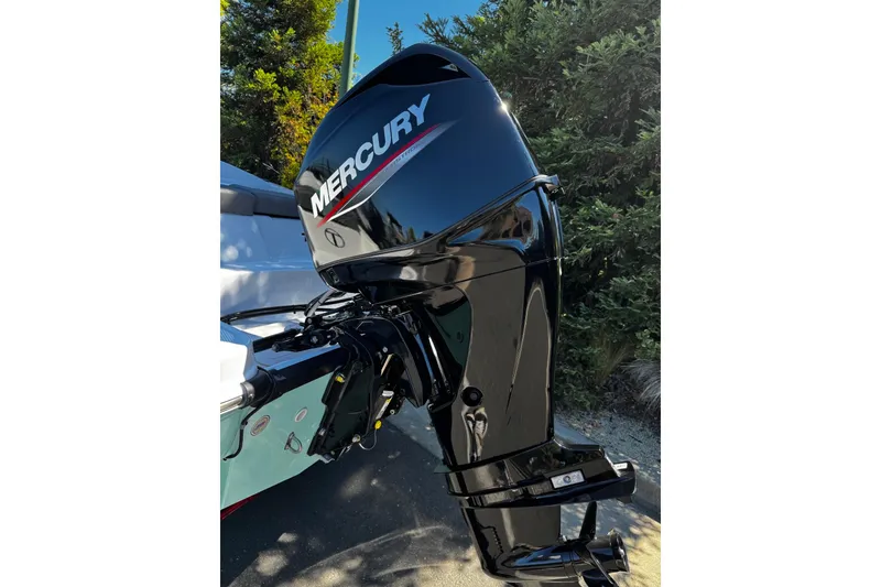 Slide: The Image of 2026 Tahoe T16 boat with Mercury outboard motor, parked outdoors. - 11