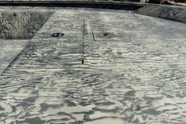 Slide: The Image of 2026 Tracker Grizzly 1754 Utility boat deck with camouflage pattern and storage compartments. - 5