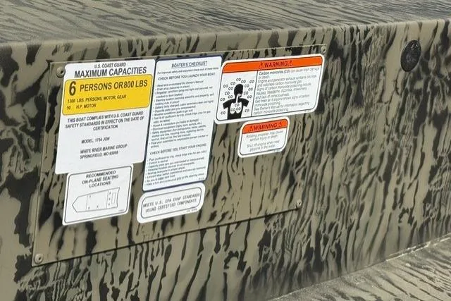 Slide: The Image of 2026 Tracker Grizzly 1754 Utility boat capacity and safety warning labels. - 8