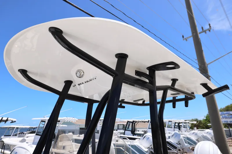Slide: The Image of 2026 Sea Hunt Ultra 219 boat T-top structure with rod holders, viewed from below. - 10